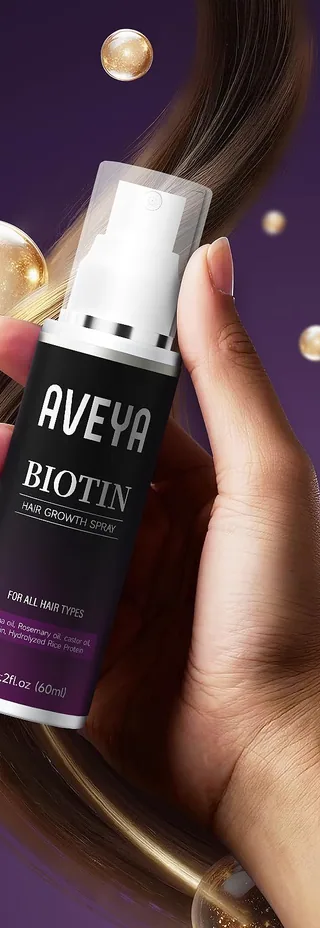 A hand holding the AVEYA Biotin Hair Growth Spray bottle
